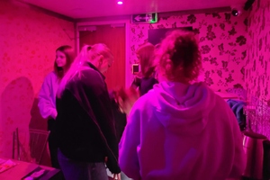 Jedno z pomieszczeń w EscapeTruck. Osoby przyglądające się pomieszczeniu.