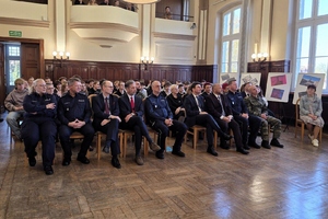  Sala, osoby siedzące na krzesłach