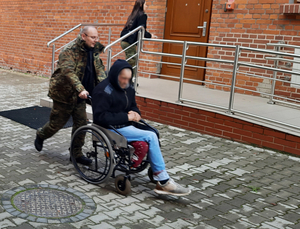 Funkcjonariusz SG oraz mężczyzna na wózku inwalidzkim 