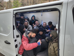 Nielegalni migranci siedzą w przestrzeni ładunkowej samochodu typu bus 