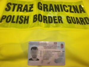 Fałszywy węgierski dokument leży na żółtej kamizelce z napisem Straż Graniczna Fałszywy węgierski dokument leży na żółtej kamizelce z napisem Straż Graniczna