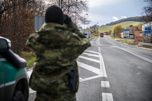 Funkcjonariuszka obserwująca drogę przez lornetkę Funkcjonariuszka obserwująca drogę przez lornetkę