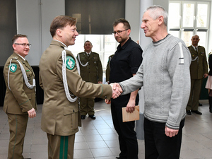 Z lewej strony gen. bryg. SG Andrzej Jakubaszek, z prawej dwóch uśmiechniętych pracowników cywilnych. Mężczyźnie w szarym swetrze i czarnych spodniach generał podaje dłoń i gratuluje. Z lewej strony gen. bryg. SG Andrzej Jakubaszek, z prawej dwóch uśmiechniętych pracowników cywilnych. Mężczyźnie w szarym swetrze i czarnych spodniach generał podaje dłoń i gratuluje.