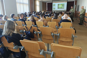 Sala wykładowa. Studenci siedzący na krzesłach. Przed nimi w górnym prawym rogu kadru stoi por. SG Szymon Mościcki i st. chor. SG Mateusz Buchta, za nimi wyświetlona jest prezentacja. Sala wykładowa. Studenci siedzący na krzesłach. Przed nimi w górnym prawym rogu kadru stoi por. SG Szymon Mościcki i st. chor. SG Mateusz Buchta, za nimi wyświetlona jest prezentacja.