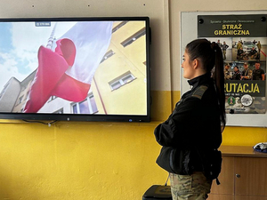 Funkcjonariuszka SG spogląda na ekran multimedialny. Funkcjonariuszka SG spogląda na ekran multimedialny.