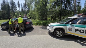  Funkcjonariusze SG prowadzą zatrzymanych: kierowce i pasażera.