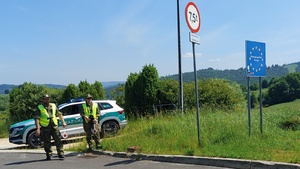  Patrol Straży Granicznej. Funkcjonariusze SG z tarczkami stop stoją przed samochodem.