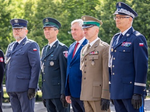  Funkcjonariusze i osoba cywilna stoją na baczność