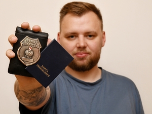  Funkcjonariusz SG w wyciągniętej dłoni trzyma legitymacje służbową i legitymacje dawcy przeszczepu