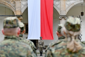  Dowódca uroczystości, za nim flaga RP