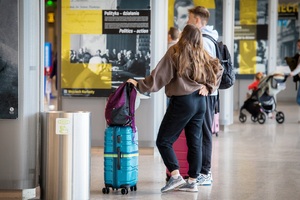Lotnisko, dziewczyna z chłopakiem spoglądają na tablice